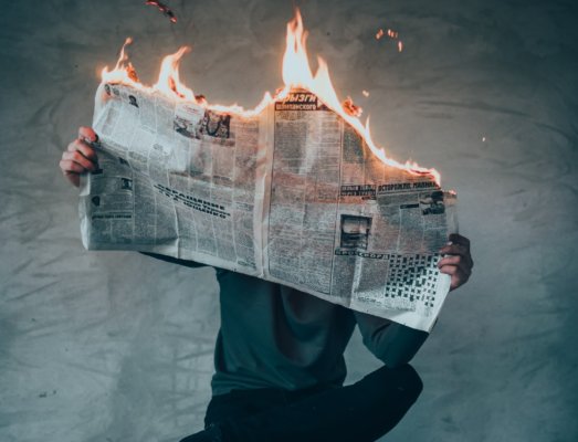 Newspapers with burning headlines showing disasters