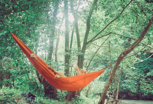 Woman relaxing in hammock in the woods